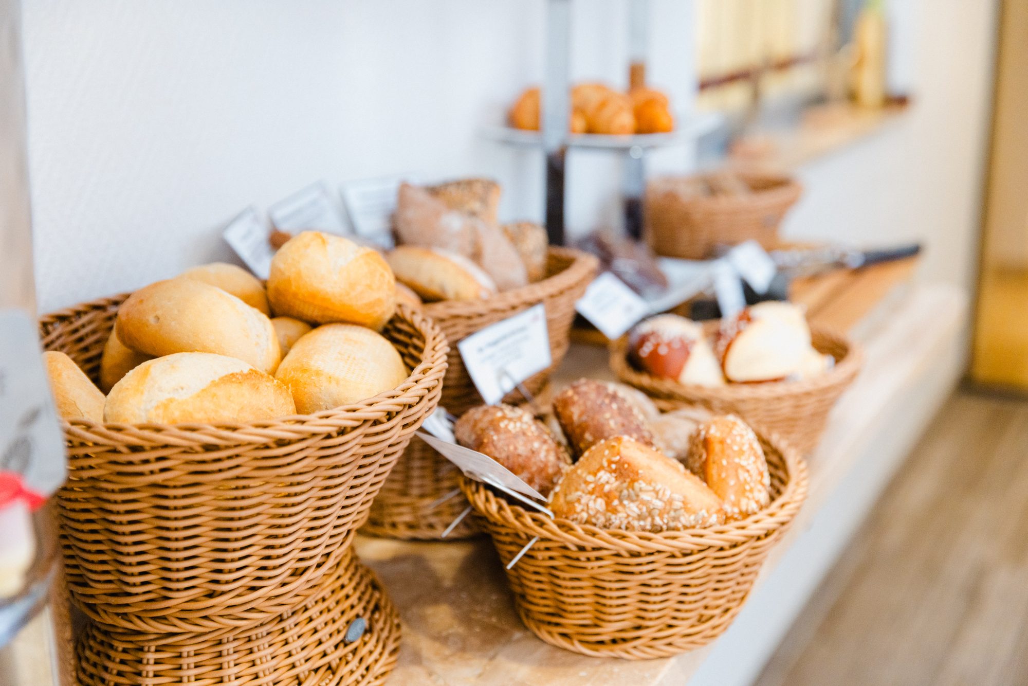 Körbe mit frischen Brötchen und Brot am Frühstücksbuffet