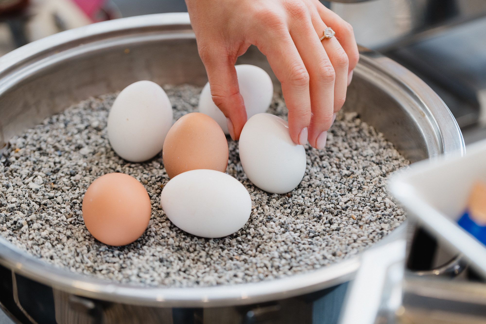 Hand nimmt ein frisches Ei aus dem Eierwärmer am Frühstücksbuffet